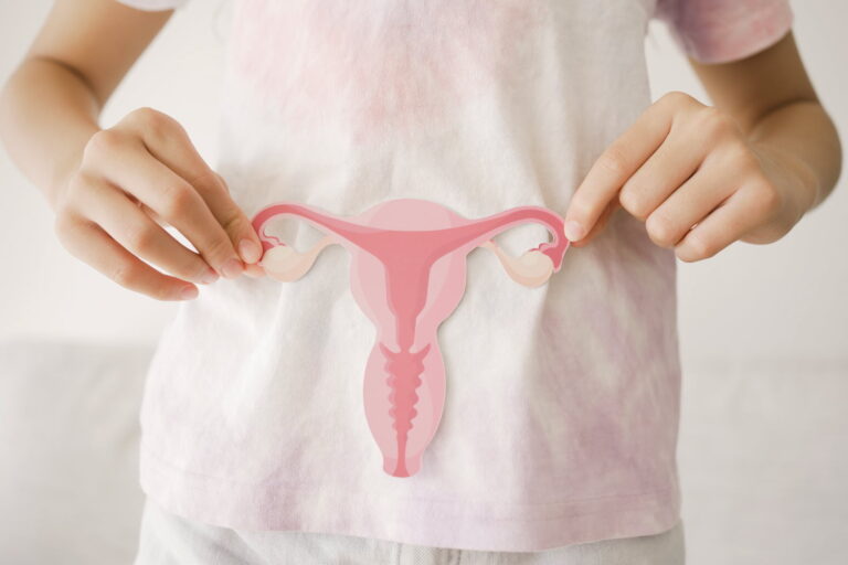 Femme touchant son ventre pour illustrer un article sur le cancer de l'endomètre et sa prise en charge.