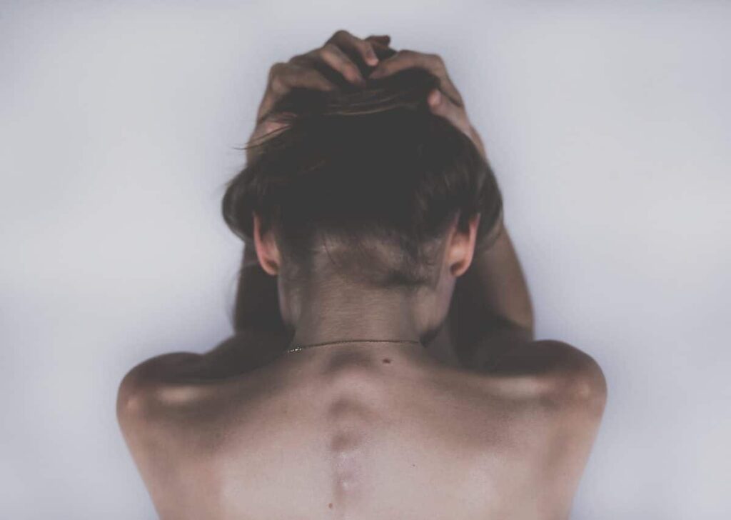 Femme souriante face à l'objectif, symbole de résilience face à la spondylarthrite ankylosante